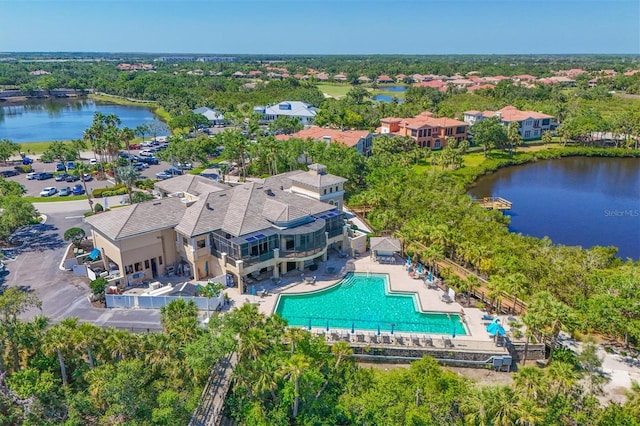 drone / aerial view of a pool and a large body of water