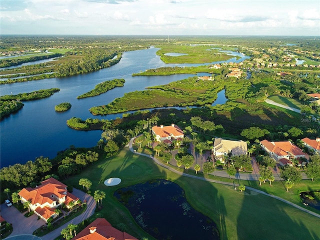 view of property location featuring a nearby body of water, nearby suburban area, and a local golf course