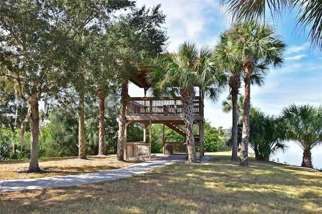 view of green lawn featuring stairs and a wooden deck