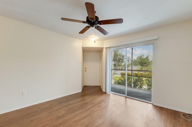 empty room with wood finished floors, ceiling fan, and baseboards