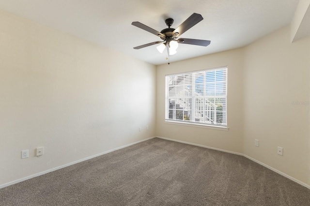 spare room with carpet floors, baseboards, and ceiling fan
