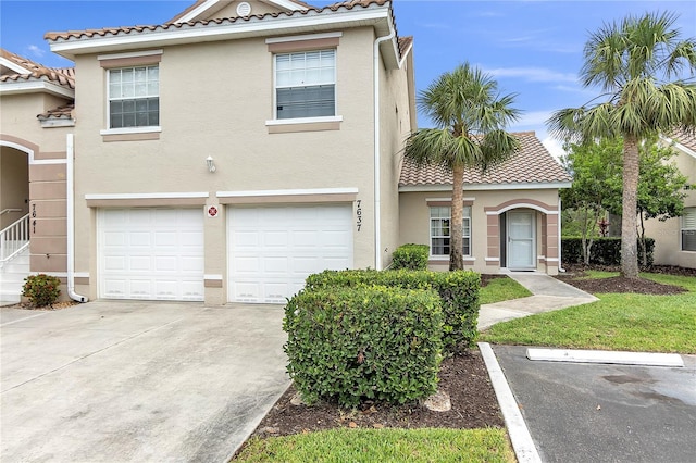 7637 Sweetbay Cir, Bradenton, FL 34203 - view of property with stucco siding, a tile roof, a garage, and driveway