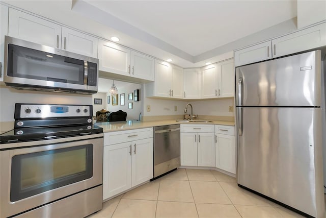 101 S Gulfstream Ave Unit 16C, Sarasota, FL 34236 - kitchen with appliances with stainless steel finishes, a sink, light countertops, light tile patterned floors, and white cabinetry