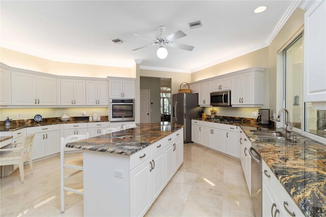 2067 Tocobaga Ln, Nokomis, FL 34275 - kitchen with appliances with stainless steel finishes, a center island, a sink, crown molding, and ceiling fan