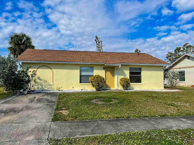 ranch-style house with stucco siding, a front lawn, and concrete driveway