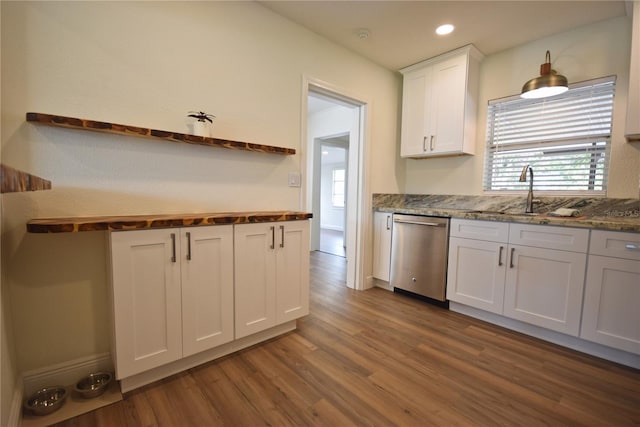 kitchen featuring stainless steel dishwasher, a sink, dark wood finished floors, white cabinetry, and healthy amount of natural light