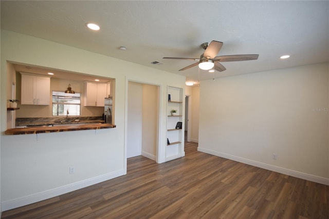unfurnished living room with ceiling fan, dark wood-style flooring, recessed lighting, baseboards, and a sink