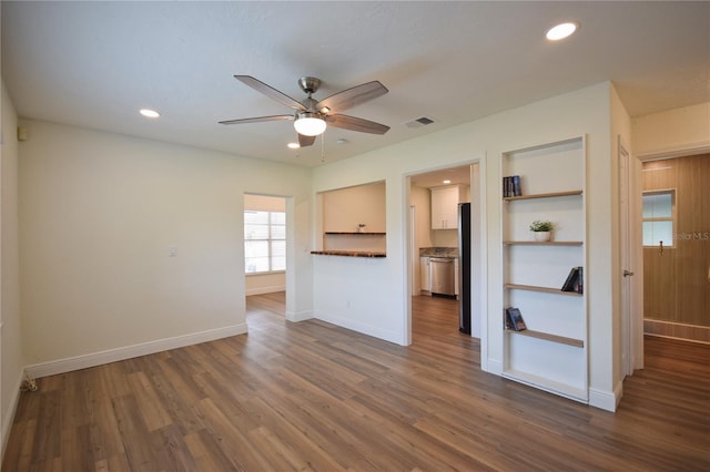unfurnished living room featuring a ceiling fan, dark wood-type flooring, baseboards, and recessed lighting