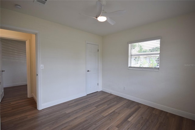 unfurnished bedroom with dark wood-style floors, baseboards, and a ceiling fan