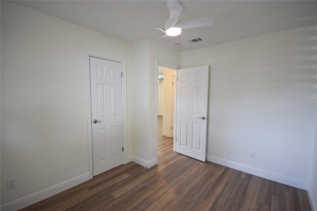 unfurnished bedroom with dark wood finished floors, baseboards, and a ceiling fan