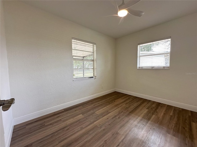 unfurnished room featuring dark wood-type flooring, baseboards, and a ceiling fan