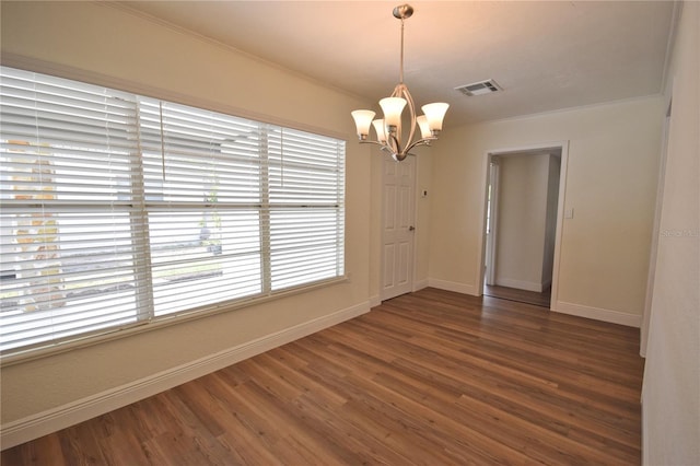 spare room with a chandelier, baseboards, and wood finished floors