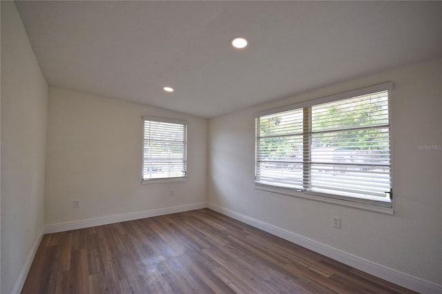 spare room featuring wood finished floors, baseboards, and recessed lighting