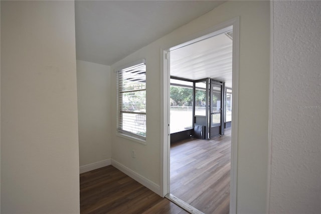 corridor with wood finished floors and baseboards