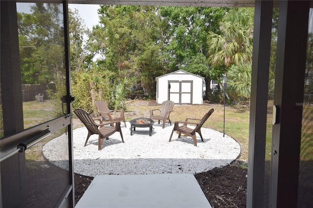 view of patio with a fire pit, a storage shed, and an outbuilding