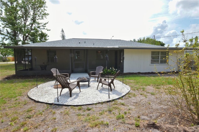rear view of property featuring an outdoor fire pit, a sunroom, and a patio area
