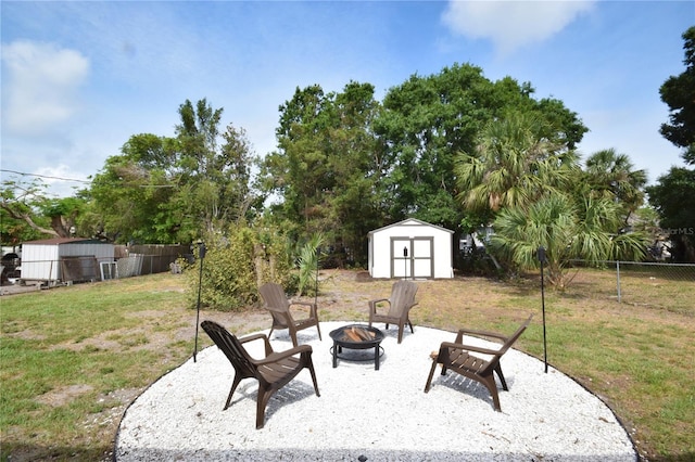 view of yard featuring a fire pit, a storage shed, an outbuilding, and a patio