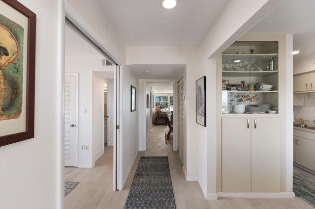 5200 Gulf Dr Unit 408, Holmes Beach, FL 34217 - hallway with light wood-type flooring, a sink, and baseboards
