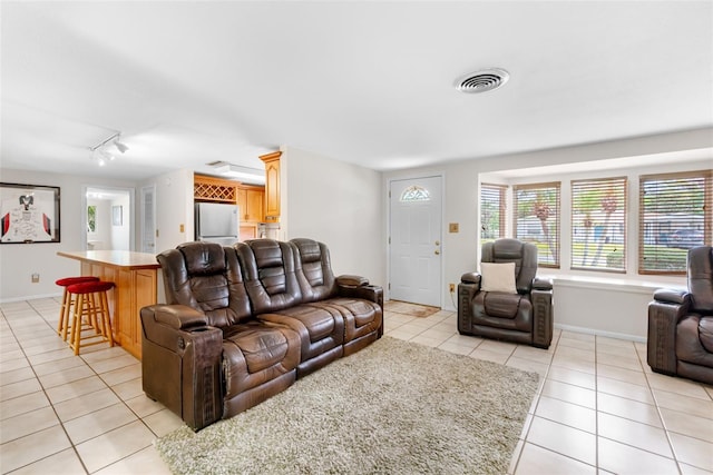 living room featuring light tile patterned floors, track lighting, and baseboards