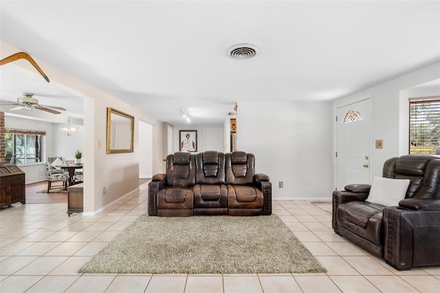 living room with light tile patterned floors, baseboards, and ceiling fan
