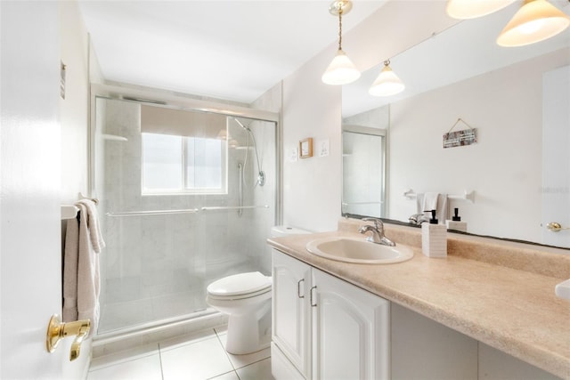 full bathroom featuring toilet, vanity, tile patterned floors, and a shower stall