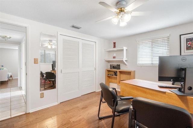 home office with ceiling fan, plenty of natural light, light wood-type flooring, and baseboards