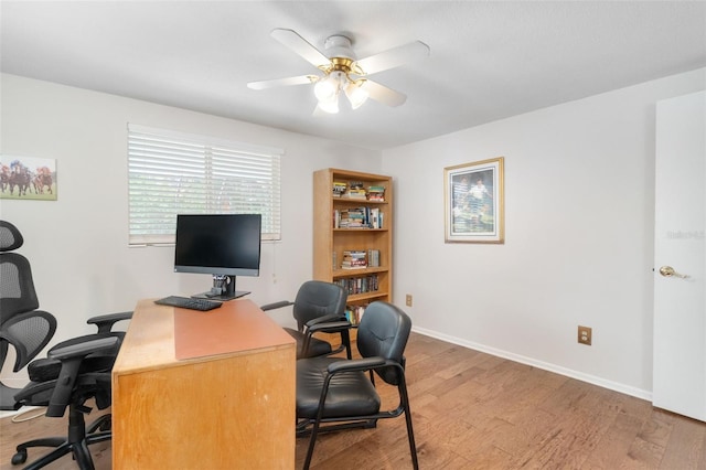 home office with light wood-style floors, ceiling fan, and baseboards