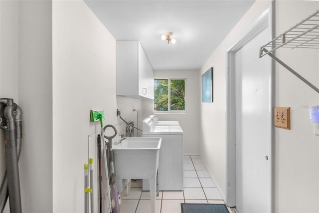 clothes washing area featuring cabinet space, washer and dryer, and light tile patterned floors