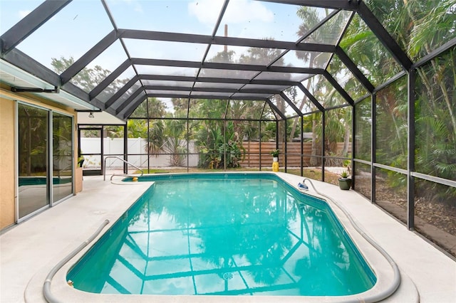 view of swimming pool featuring a patio, a fenced backyard, and a lanai