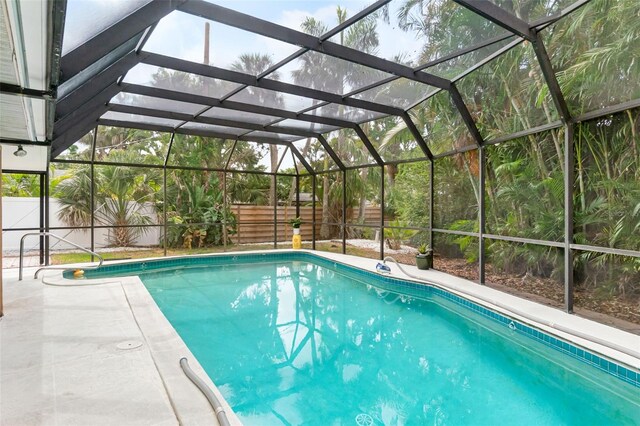 view of swimming pool with a fenced backyard, a lanai, and a patio area