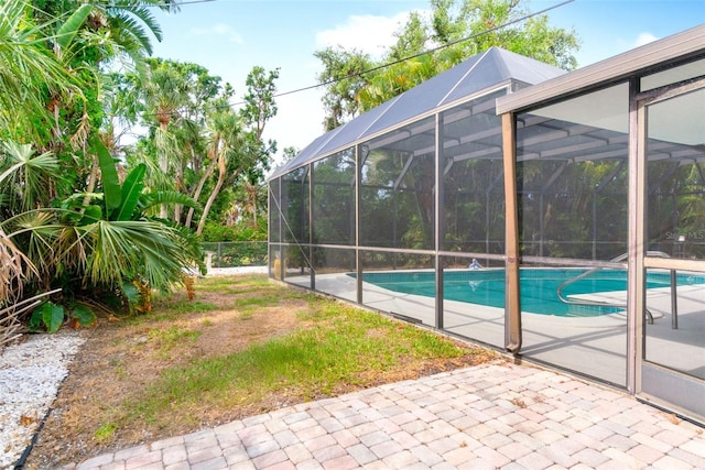 swimming pool featuring fence, a patio area, and a lanai