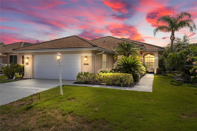 6764 Hickory Hammock Cir, Bradenton, FL 34202 - mediterranean / spanish-style home featuring a garage, a tile roof, stucco siding, concrete driveway, and a yard