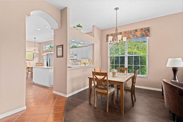 6764 Hickory Hammock Cir, Bradenton, FL 34202 - dining space featuring a chandelier, baseboards, and arched walkways
