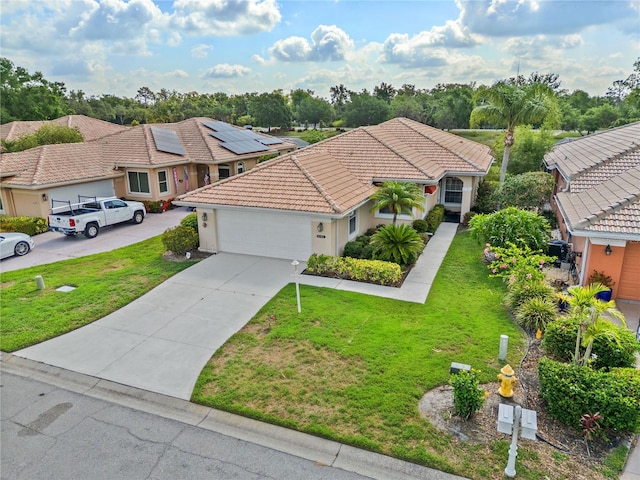 6764 Hickory Hammock Cir, Bradenton, FL 34202 - mediterranean / spanish-style house featuring an attached garage, concrete driveway, a tile roof, and a front yard