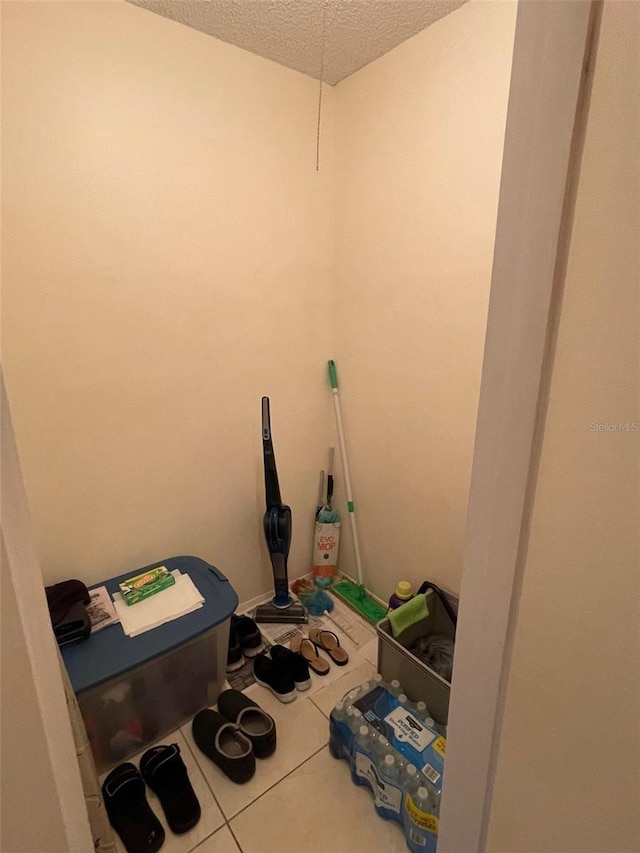 laundry room featuring a textured ceiling and tile patterned floors