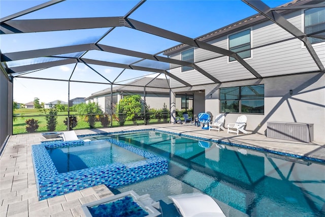view of pool with a pool with connected hot tub, a patio, and a lanai
