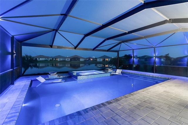 view of pool featuring glass enclosure, a pool with connected hot tub, and a patio area