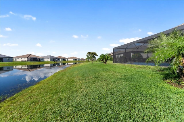 view of green lawn featuring a water view and a residential view