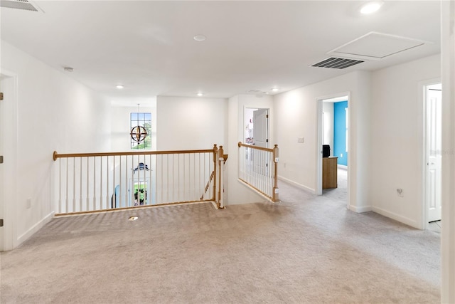 carpeted spare room featuring baseboards, recessed lighting, and attic access