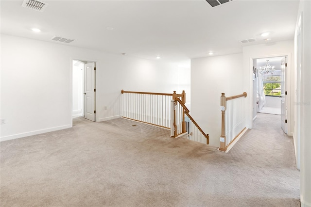 carpeted spare room featuring recessed lighting, baseboards, and a chandelier