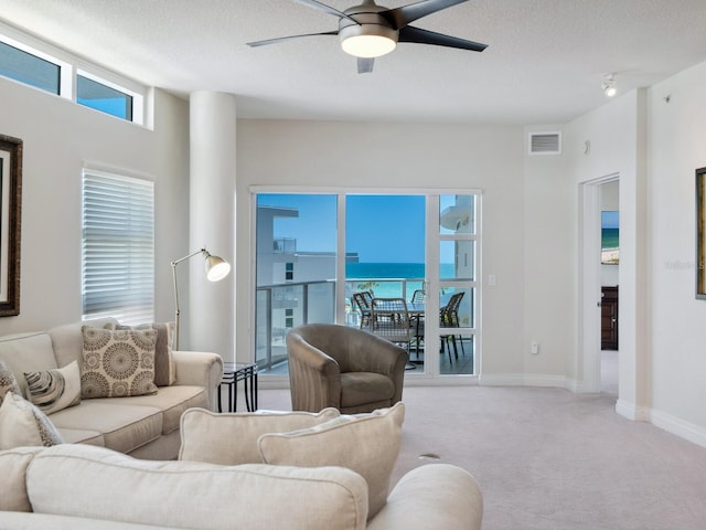 6512 Midnight Pass Rd Unit 303, Sarasota, FL 34242 - carpeted living room featuring a ceiling fan, a water view, a textured ceiling, and baseboards