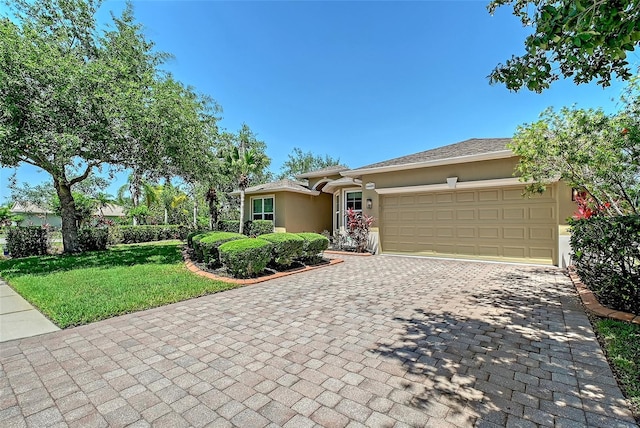 6605 38th Ln E, Sarasota, FL 34243 - view of front of house with stucco siding, an attached garage, decorative driveway, and a front lawn