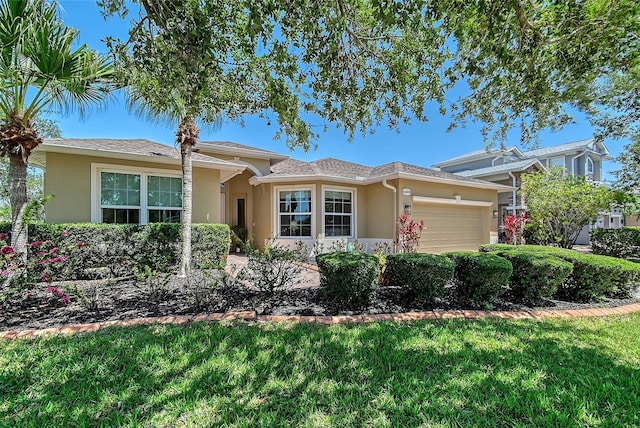 6605 38th Ln E, Sarasota, FL 34243 - view of front of property featuring stucco siding, an attached garage, and a front yard