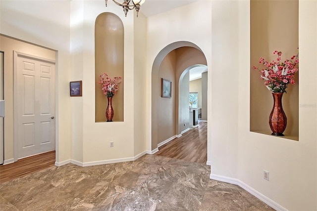 6605 38th Ln E, Sarasota, FL 34243 - corridor with arched walkways, a towering ceiling, baseboards, and marble finish floors
