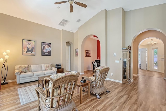 6605 38th Ln E, Sarasota, FL 34243 - living room with arched walkways, a ceiling fan, high vaulted ceiling, light wood-style flooring, and baseboards