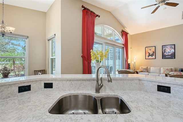 6605 38th Ln E, Sarasota, FL 34243 - kitchen featuring a sink, lofted ceiling, ceiling fan, plenty of natural light, and light stone counters