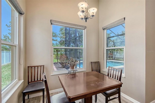 6605 38th Ln E, Sarasota, FL 34243 - dining room with baseboards, wood finished floors, healthy amount of natural light, and a chandelier