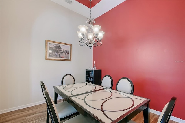 6605 38th Ln E, Sarasota, FL 34243 - dining room with a chandelier, wood finished floors, baseboards, and a towering ceiling