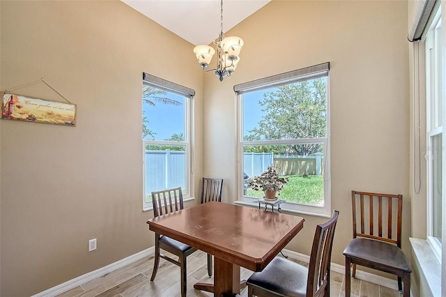 6605 38th Ln E, Sarasota, FL 34243 - dining area featuring a chandelier, plenty of natural light, baseboards, light wood-style floors, and vaulted ceiling