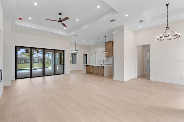 117 Marker Rd, Rotonda West, FL 33947 - unfurnished living room with a tray ceiling, a chandelier, baseboards, recessed lighting, and a towering ceiling